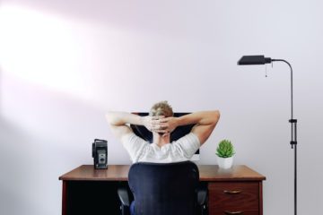 Man leaning back at computer and thinking