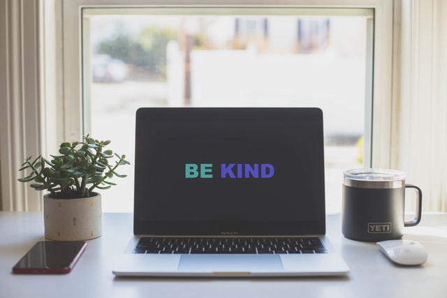 Computer with "Be Kind" on screen